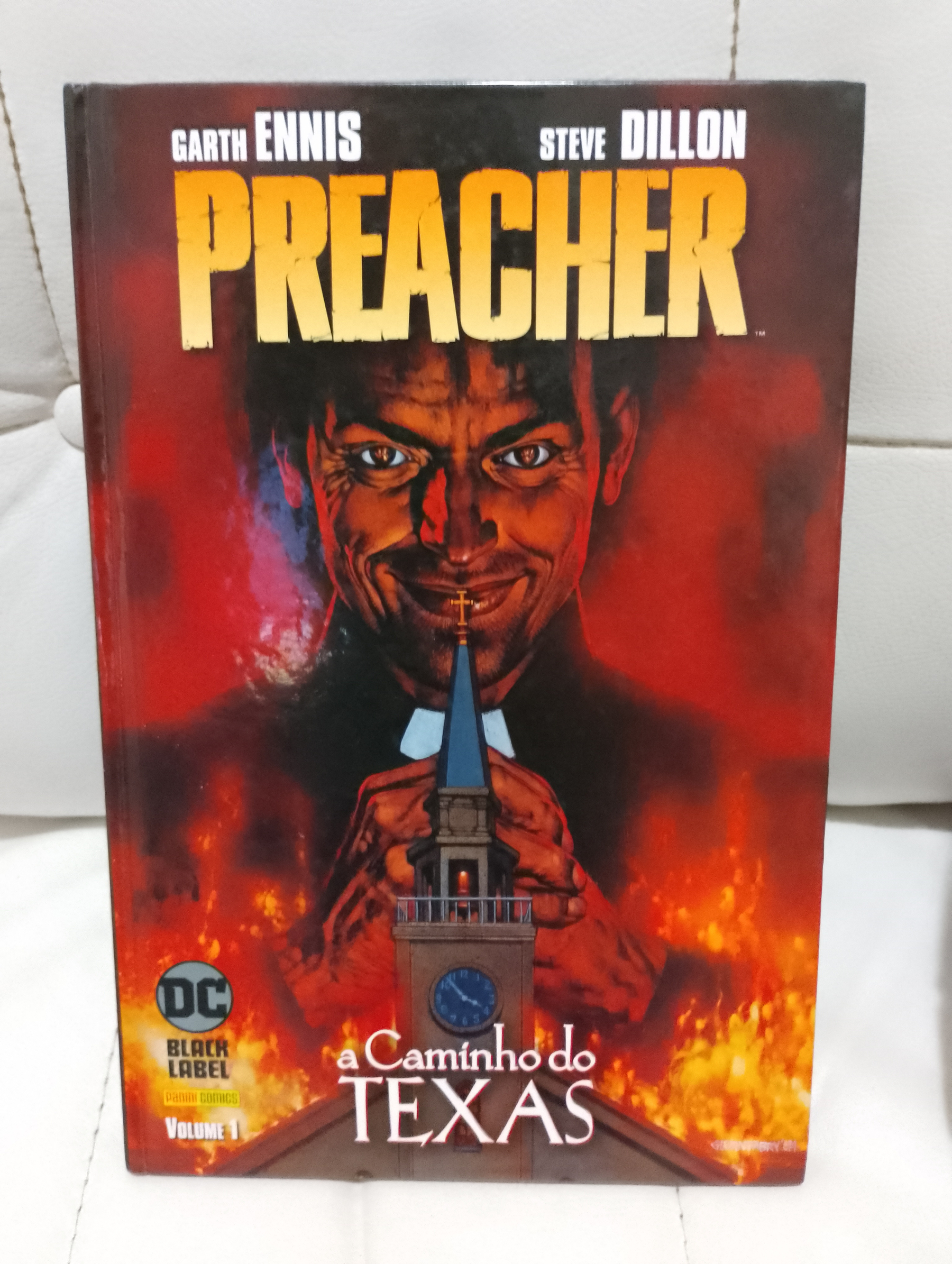 Auto-generated description: Capa do quadrinho Preacher: A Caminho do Texas, apresentando um homem sorrindo sinistramente com uma igreja em chamas ao fundo.