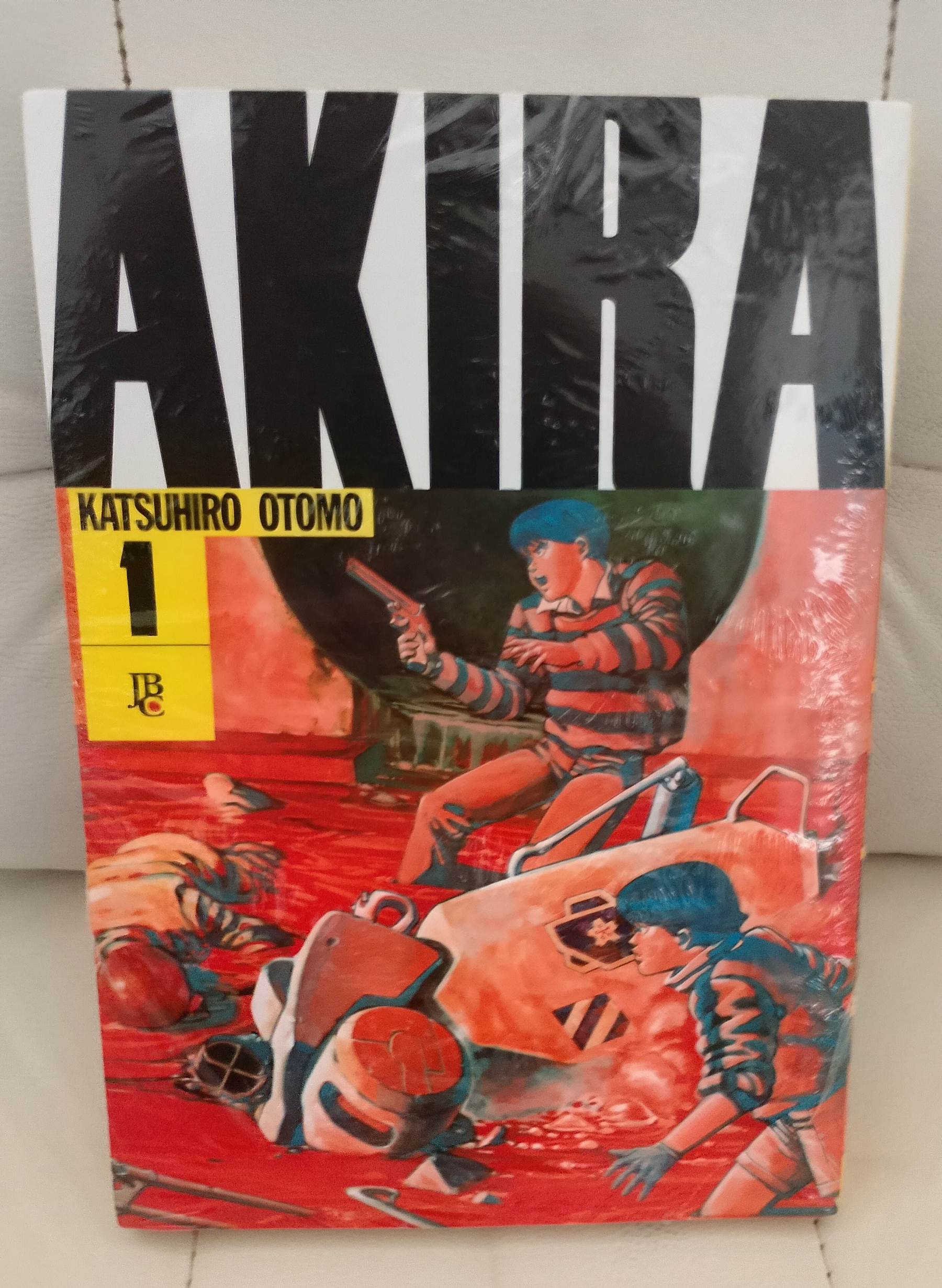 Capa do mangá Akira de Katsuhiro Otomo, mostrando personagens em ação com fundo vermelho e o número 1 destacado.